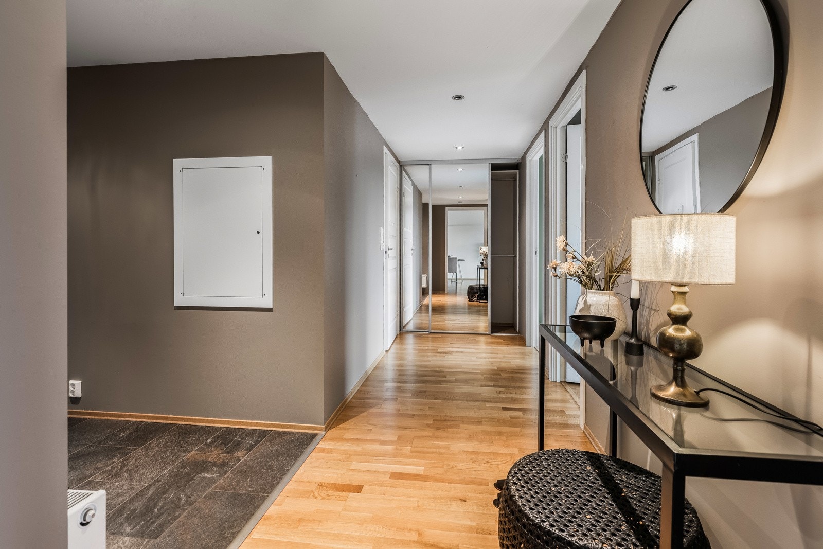 Entreen har blant annet mørke fliser på gulv, downlights i himling og dørcalling Galleribilde