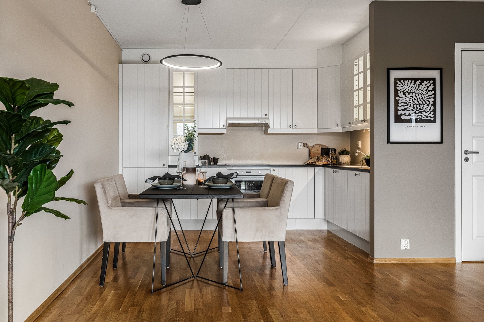 Innredningen har hvite, profilerte fronter, vitrineskap med lys, laminert benkeplate og planlimt stålkum. Galleribilde