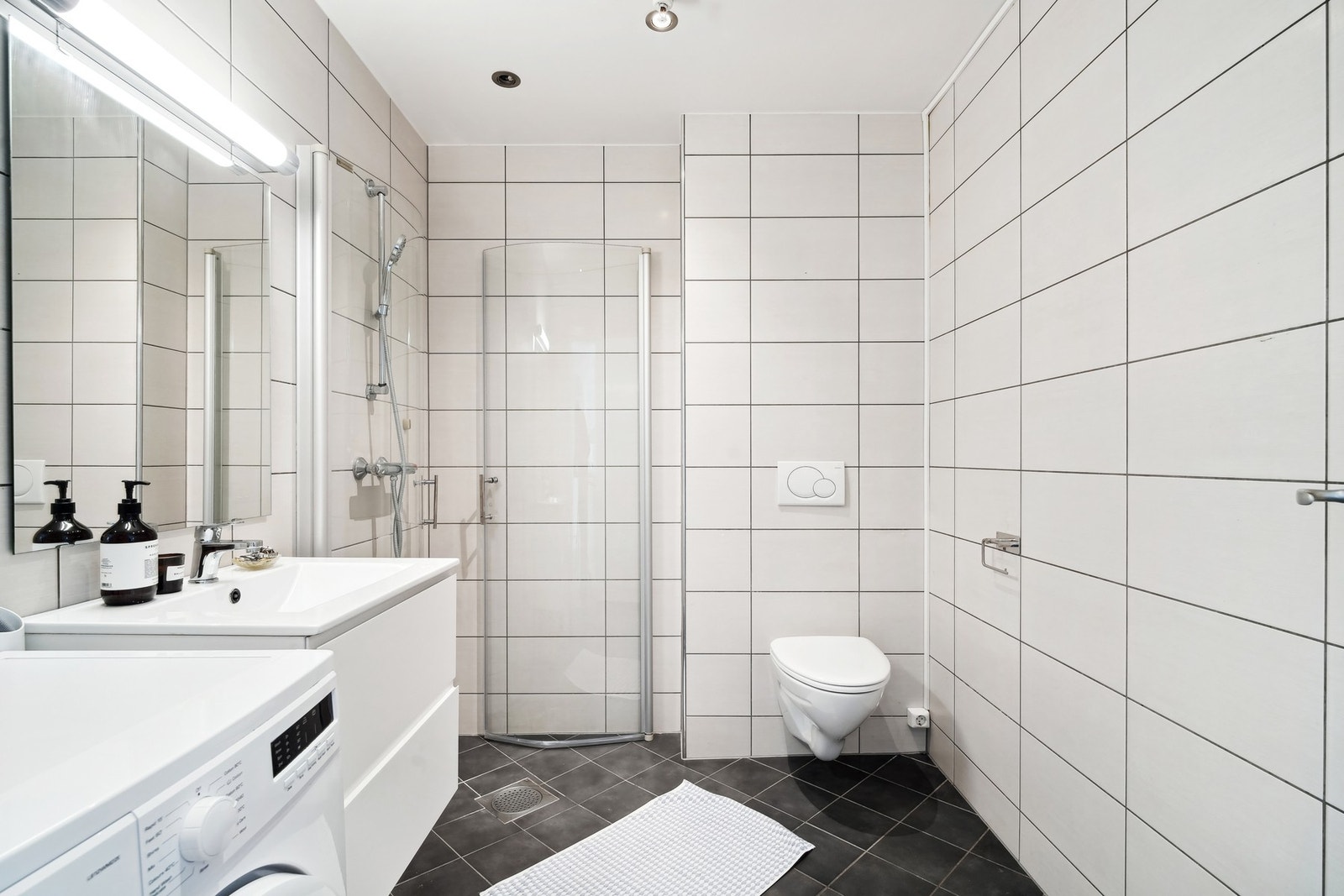 Badet holder en fin størrelse og er helfliset i nøytrale fargevalg med elektriske varmekabler i gulvet. Galleribilde