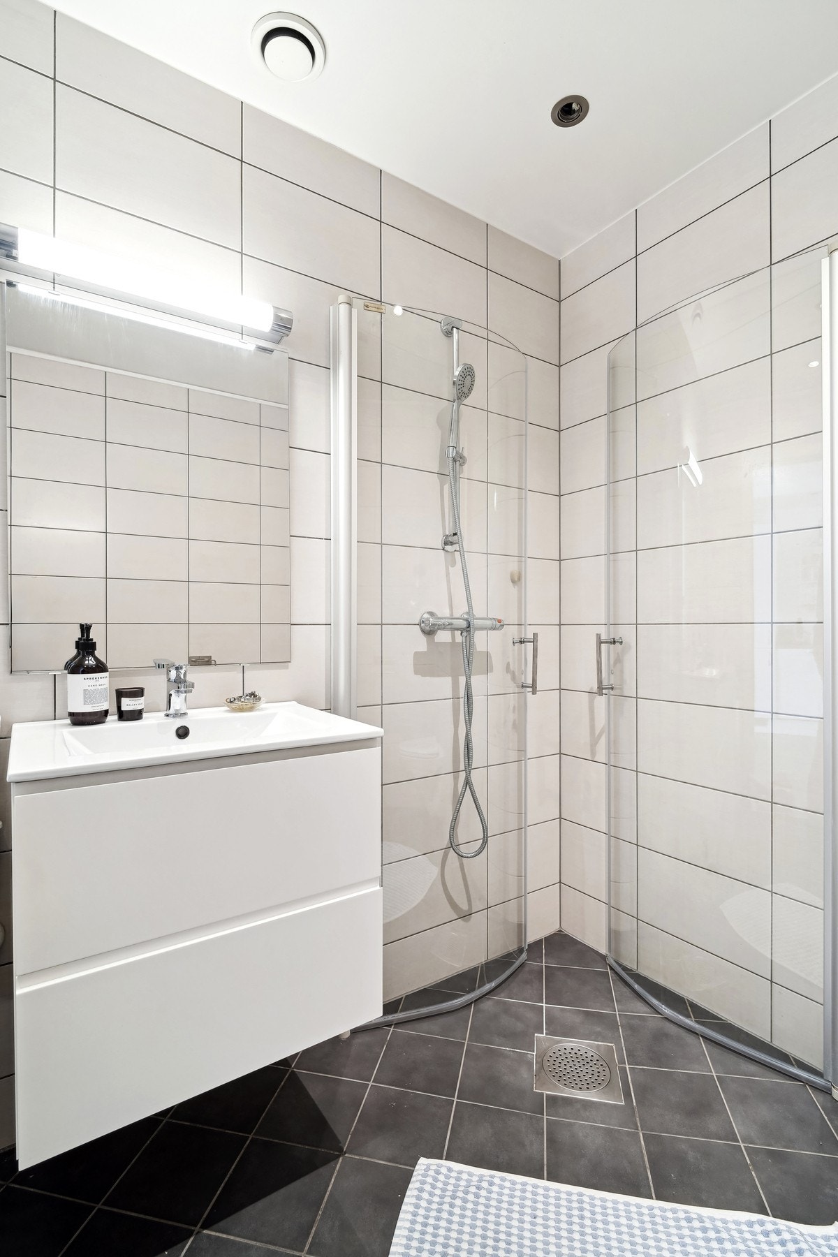 Badet er utstyrt med vegghengt toalett og dusjhjørne med innsvingbare dører. Galleribilde