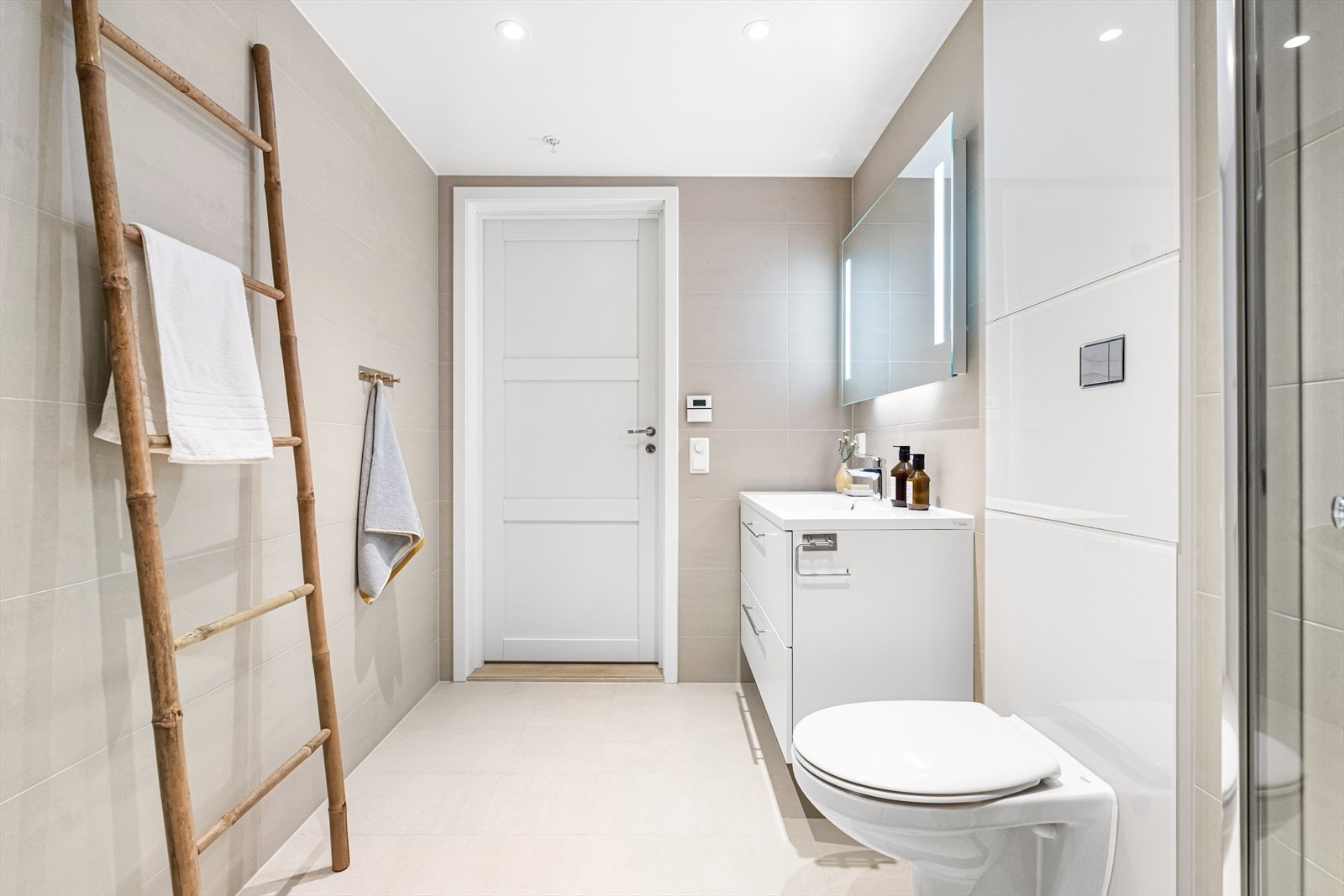 Badet er svært delikat innredet med beige fliser, downlights i himling og vannbåren gulvvarme. Galleribilde