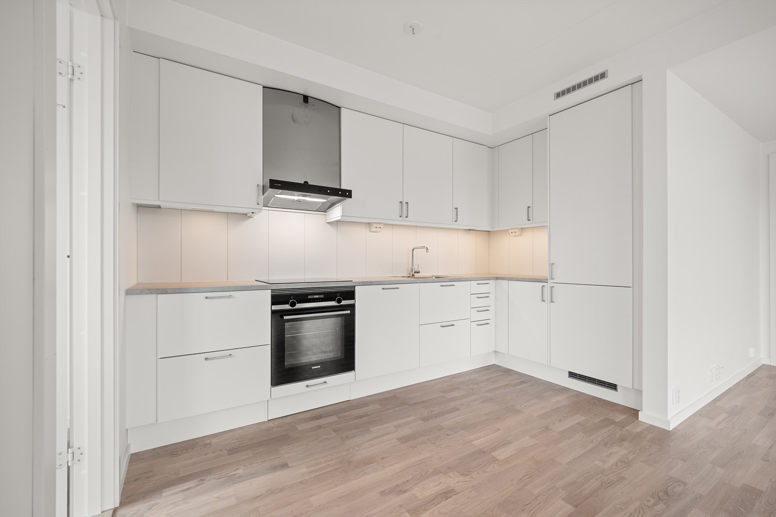 Det moderne Marbodal-kjøkkenet har slette, lyse fronter og en benkeplate i slitesterkt laminat Galleribilde