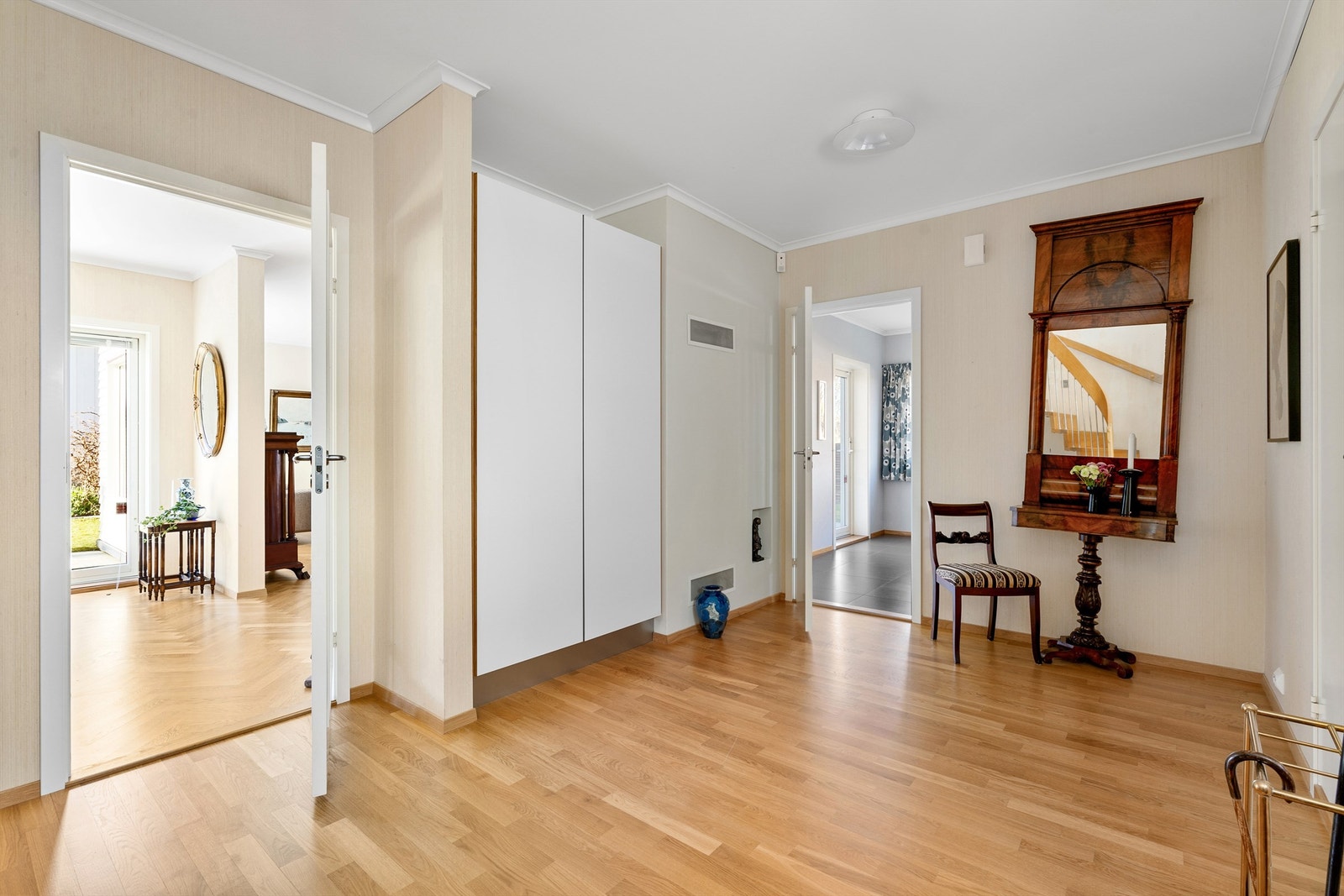 Gjennom flott teak inngangsdør kommer man inn til en meget romslig og åpen entré med parkett på gulv, garderobeskap fra HTH med god oppbevaringsplass til yttertøy. Galleribilde