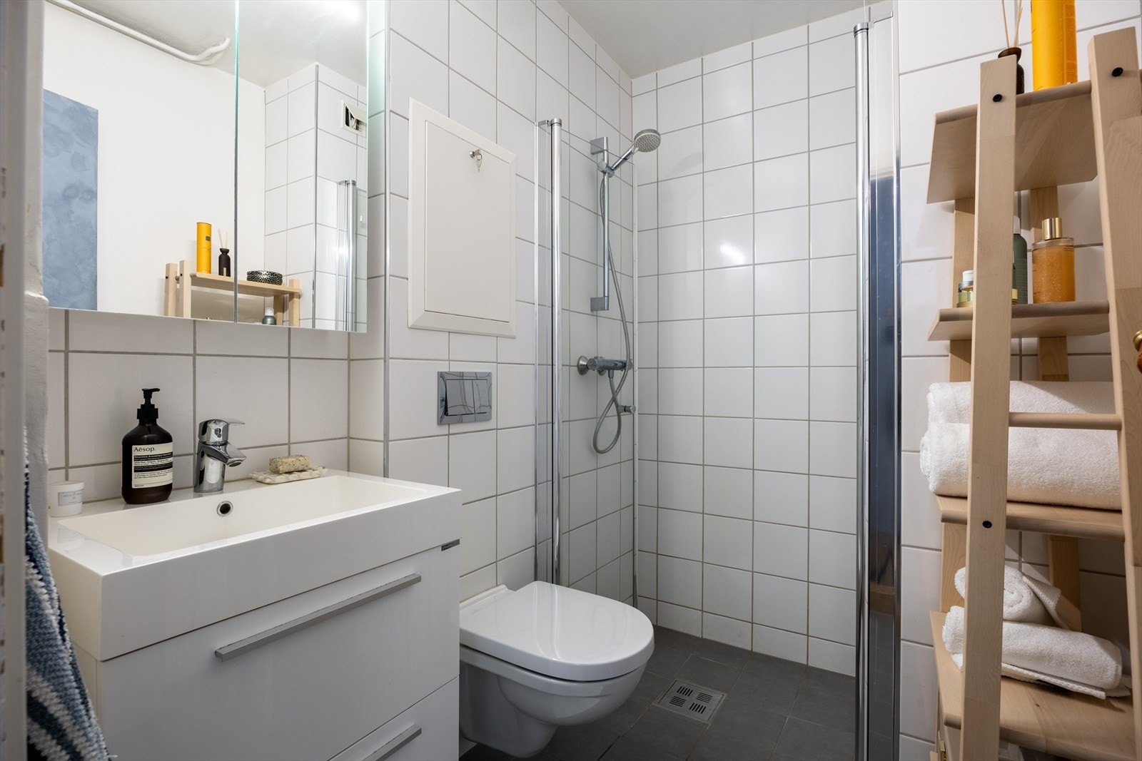 Romslig bad med dusjhjørne, vegghengt wc, servant med skuffer og speilskap. Galleribilde