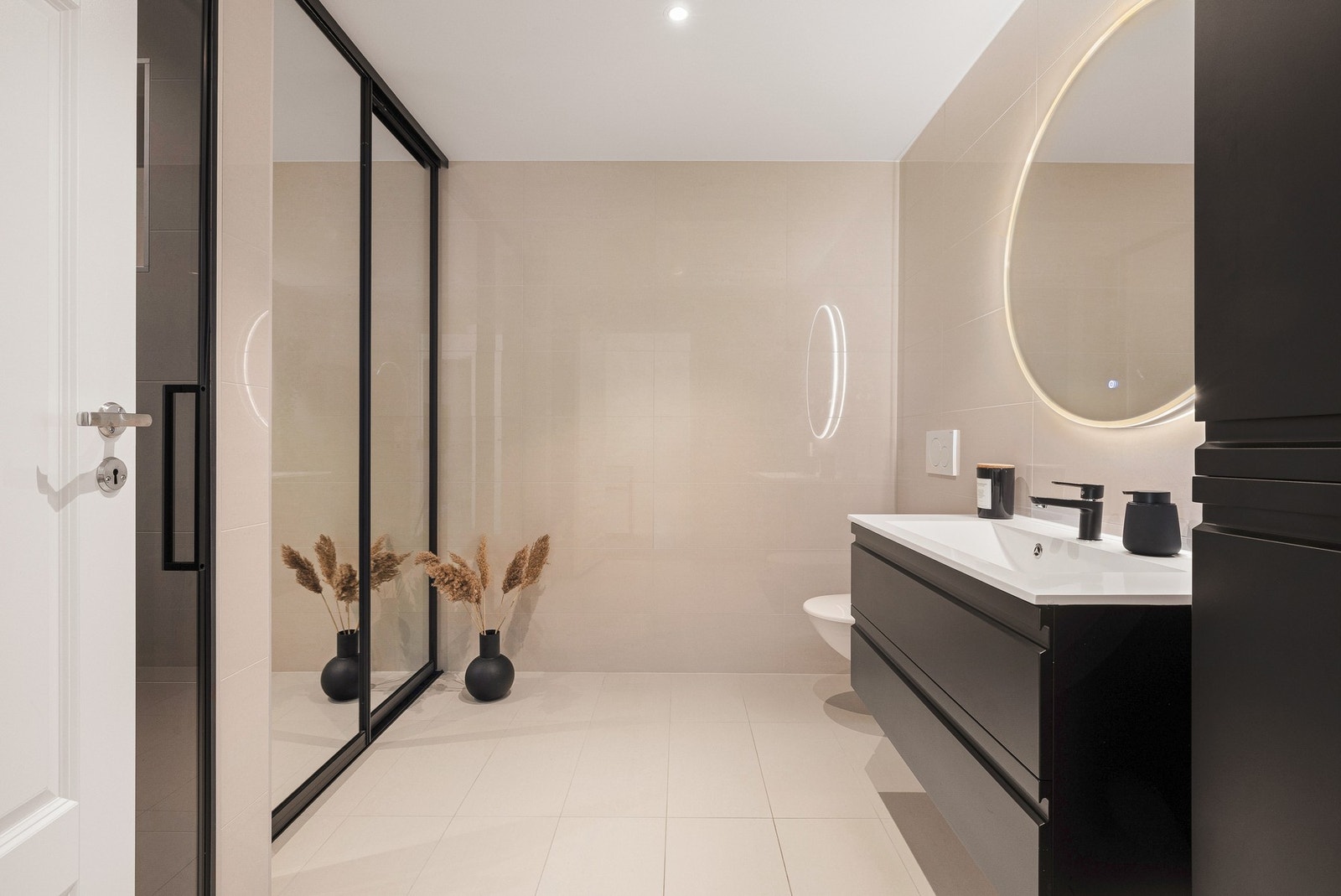 Baderommet har store elegante fliser samt speil med stemningsfull belysning. Galleribilde