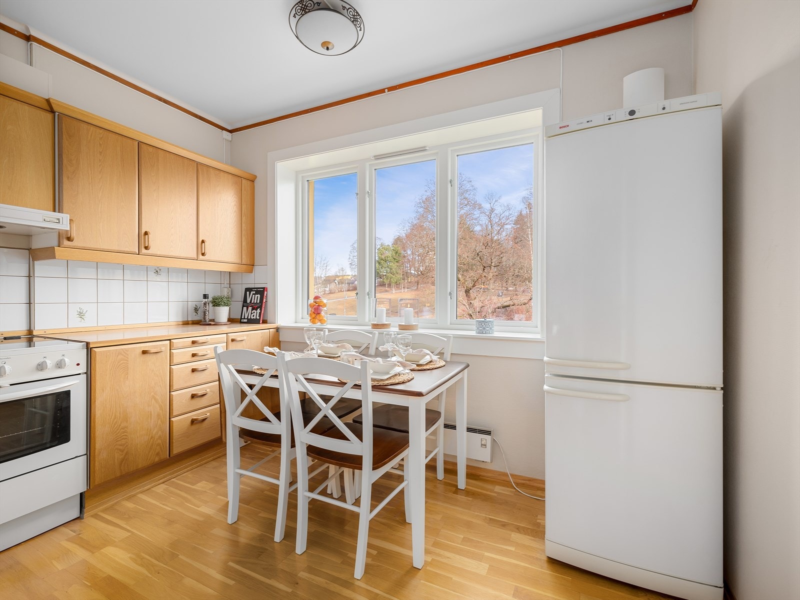 Koselig kjøkken med spiseplass ved vinduet med hyggelig utsyn over Bjølsenparken. Galleribilde