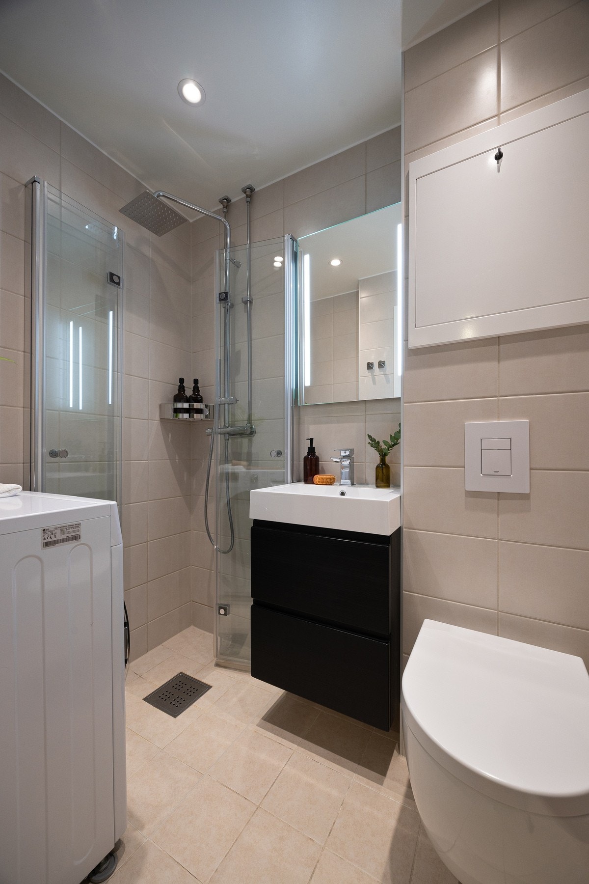 Flislagt bad med varmekabler i gulv og opplegg for vaskemaskin. Galleribilde