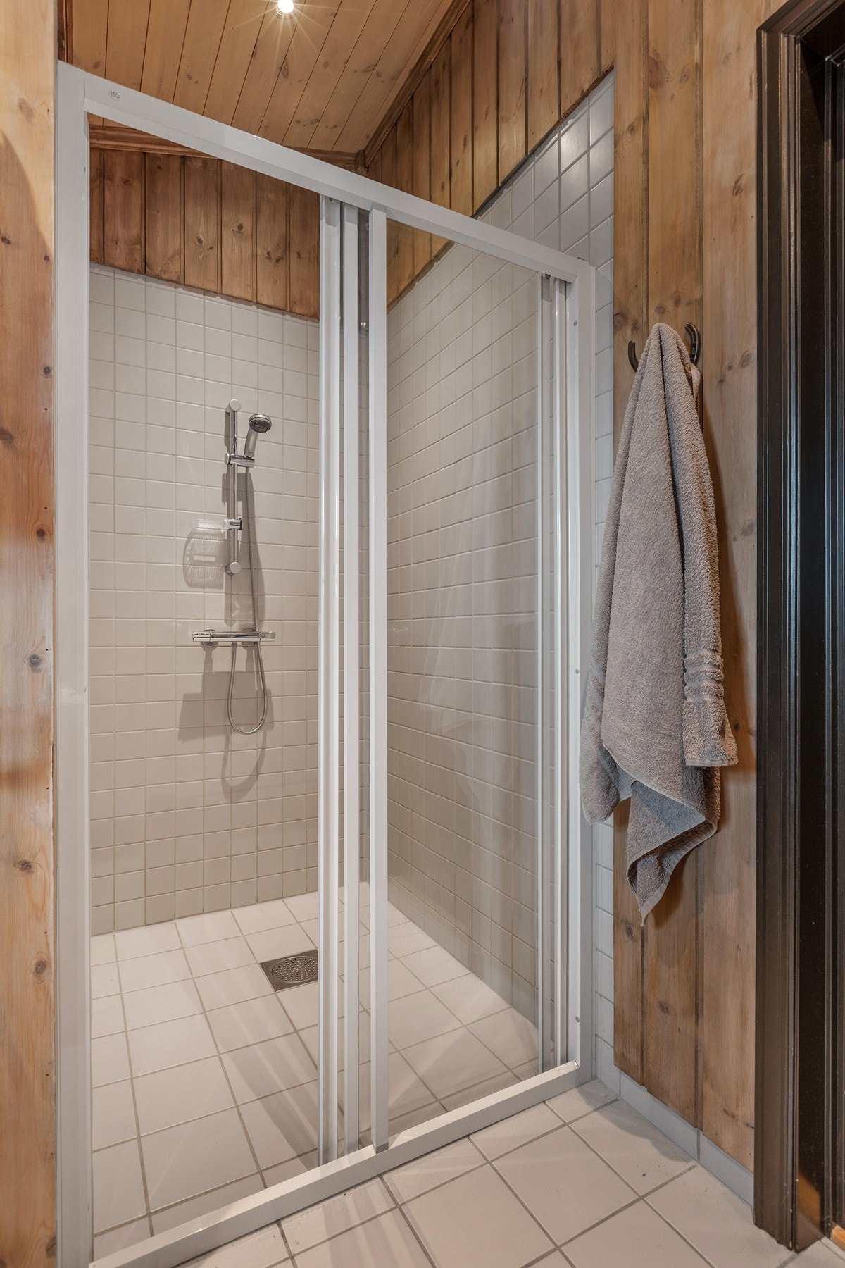 Flislagt dusjsone med skyvedører i herdet glass. Galleribilde