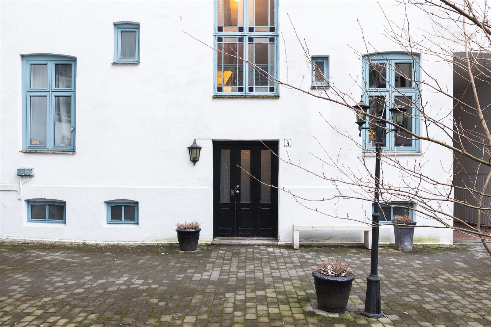 Inngang via rolig, lukket bakgård. Sykkelparkering og hyggelig beplantning. Galleribilde