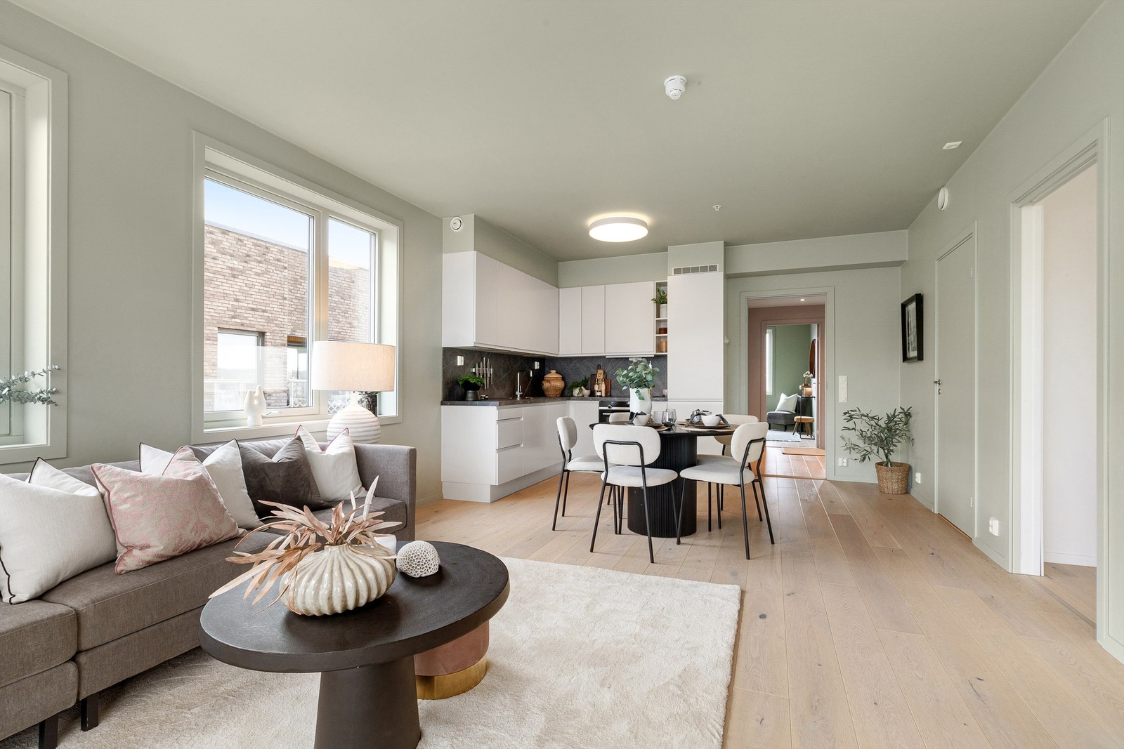 Slette malt flater på vegger med himling malt i samme farge, og listefrie overganger til tak er med på å gi en moderne og minimalistisk preg på leiligheten Galleribilde