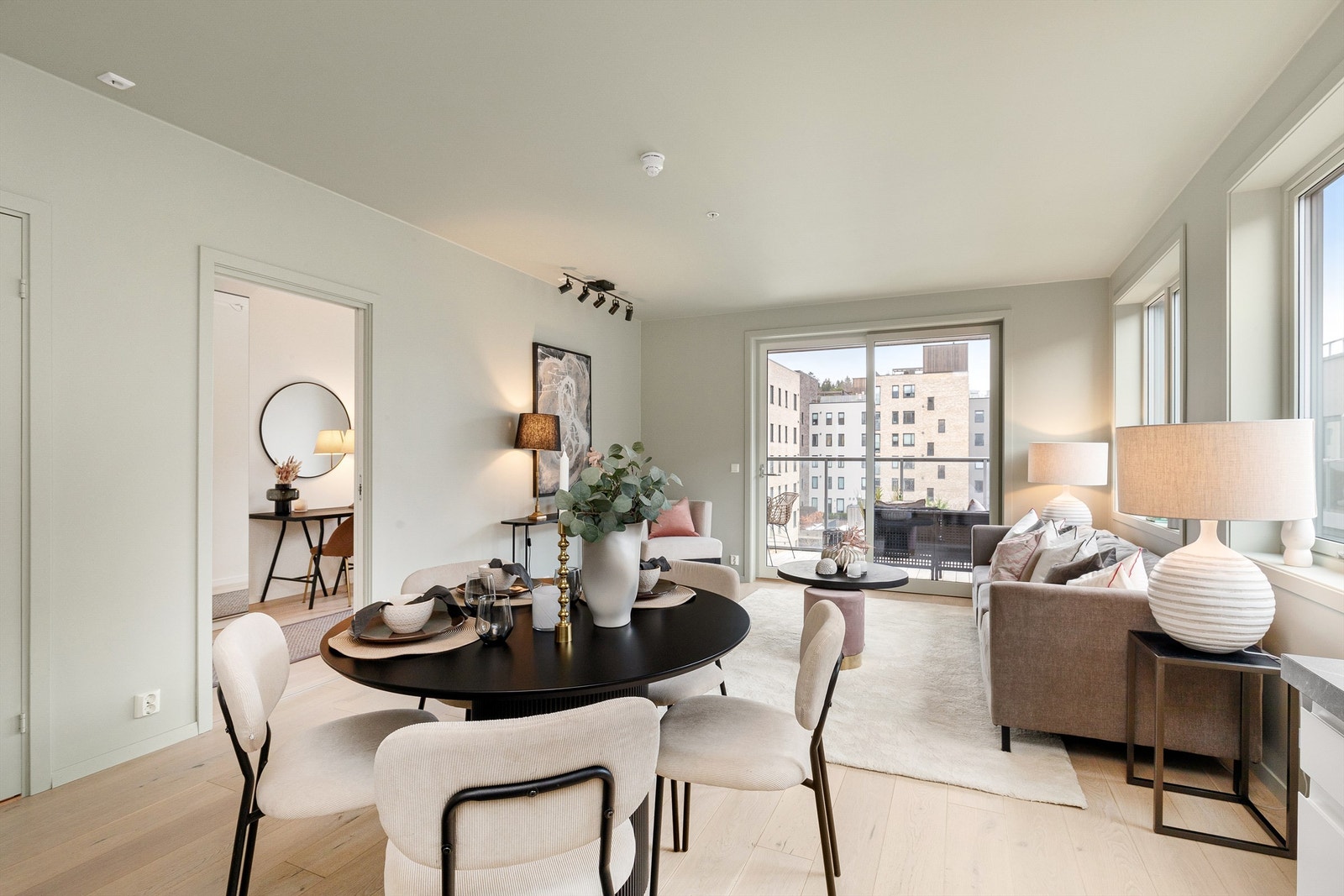 Leilighetens oppholdsrom har åpen løsning mellom stue og kjøkken, samt store vindusflater på flere vegger som gir masse naturlig lys til leiligheten Galleribilde