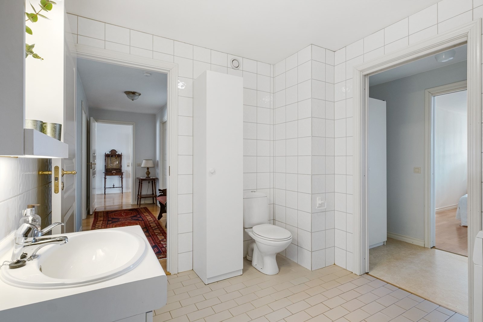 Badet er innredet med nedsenket servant med skapplass under, speil med lys, gulvmontert toalett, høyskap og badekar samt opplegg for vaskemaskin Galleribilde