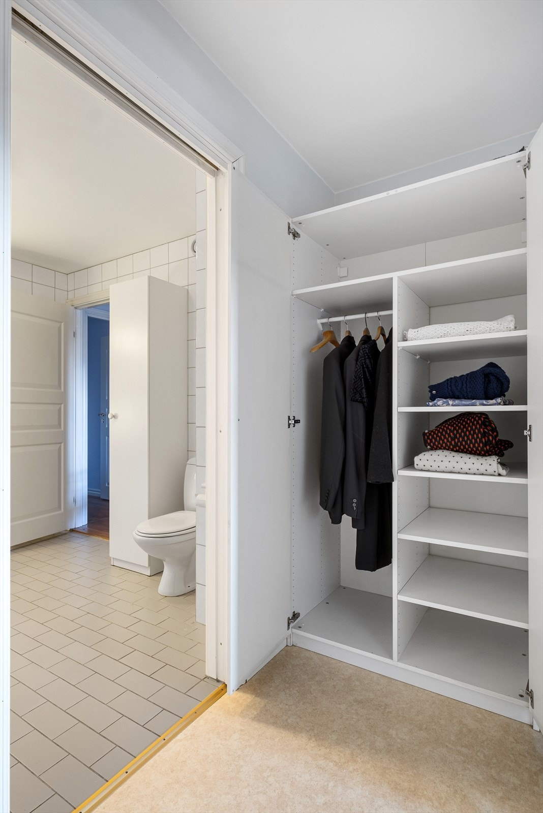 Walk-in closet er innredet med garderobeskap Galleribilde