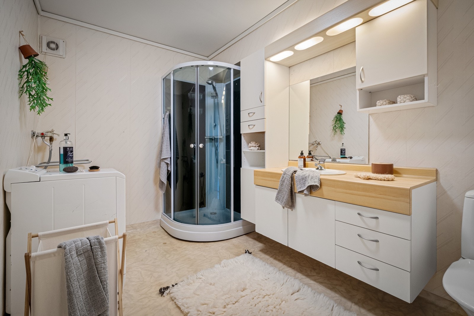 Videre følger badet - Badet er praktisk innredet med dusjkabinett, servant og plass til vaskemaskin Galleribilde