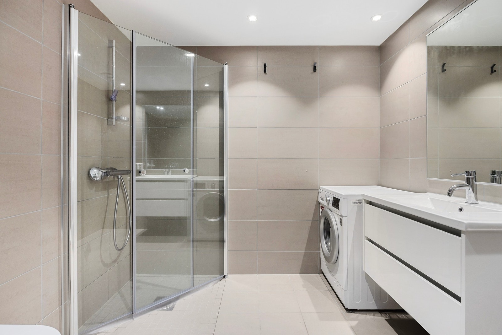 Et delikat bad fra 2024 med flislagte flater og downlights i taket. Galleribilde