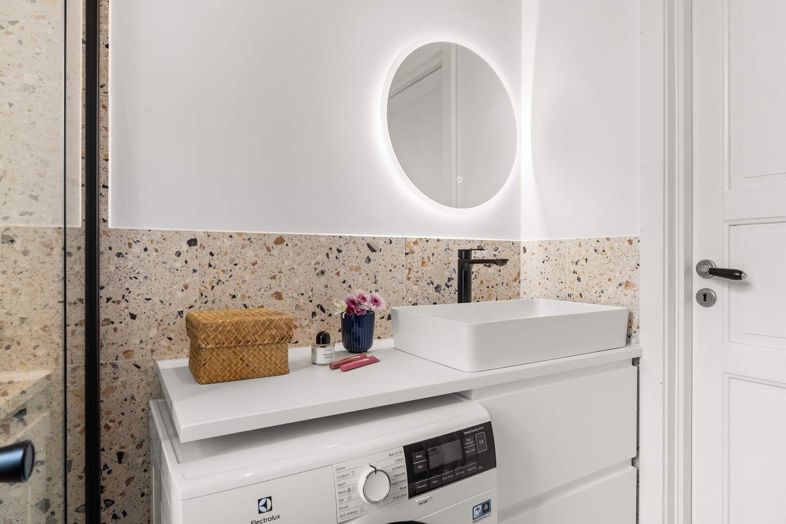 Her er det opplegg for vaskemaskin med flott benkeplate over med servant og veggfestet speil Galleribilde