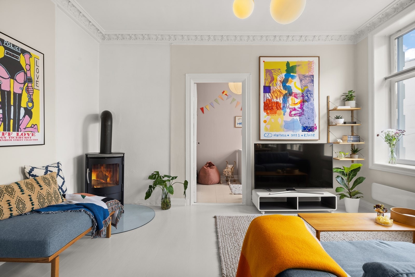 Store vindusflater, generøs takhøyde og peis gjør stuen til et meget behagelig oppholdsrom Galleribilde