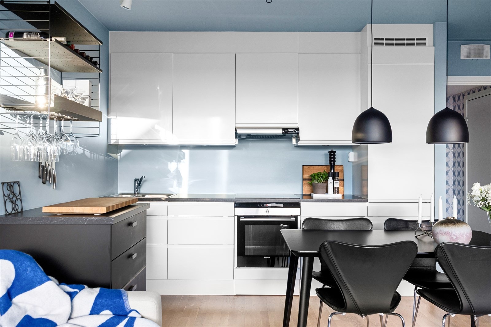 Moderne HTH-kjøkken med rikelig skap- og benkeplass. Kjøkkenet har hvite, glatte fronter og en slitesterk laminatbenkeplate med nedfelt oppvaskkum og ettgreps, svingbart blandebatteri. Galleribilde