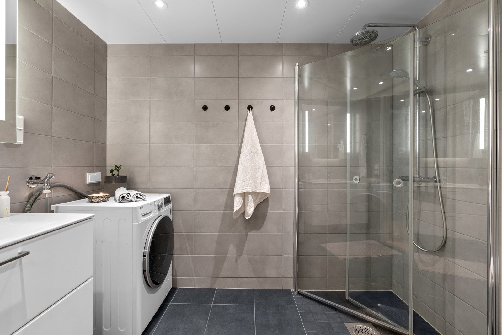 Romslig baderom med tilgang fra gangen. Speil med integrert belysning og regnfallsdusj gir badet det lille ekstra Galleribilde