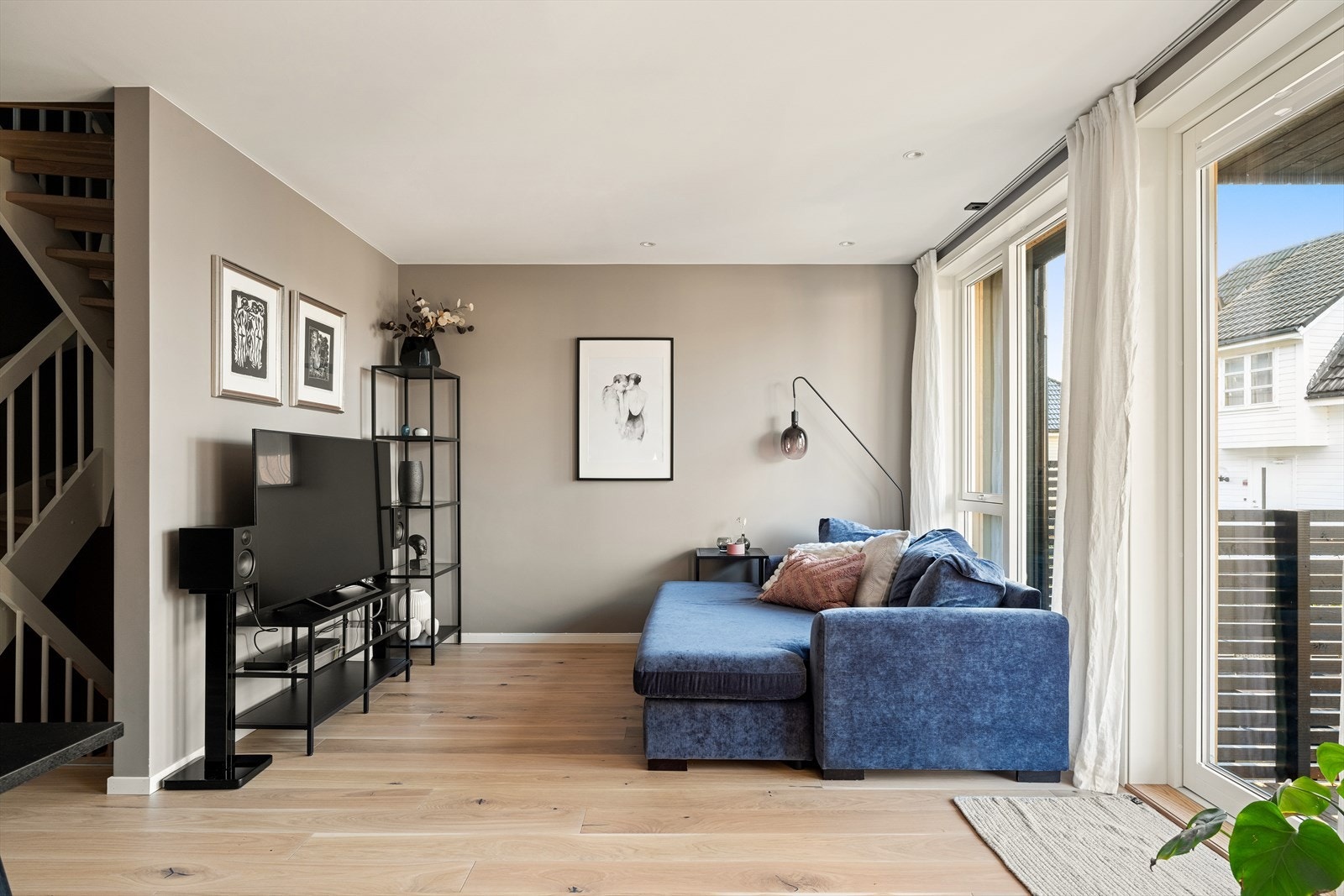 Store vindusflater i stuen som slipper inn rikelig med naturlig dagslys. Galleribilde