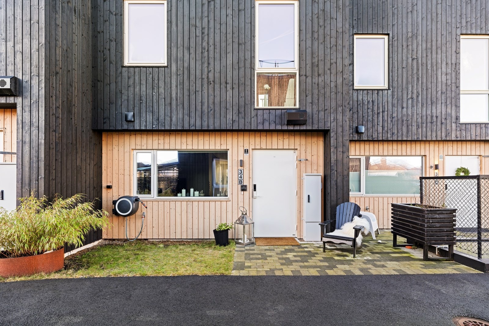 Pent og velstelt inngangsparti opparbeidet med gressplen og platting. Her kan man sitte og nye formiddagssolen. Galleribilde