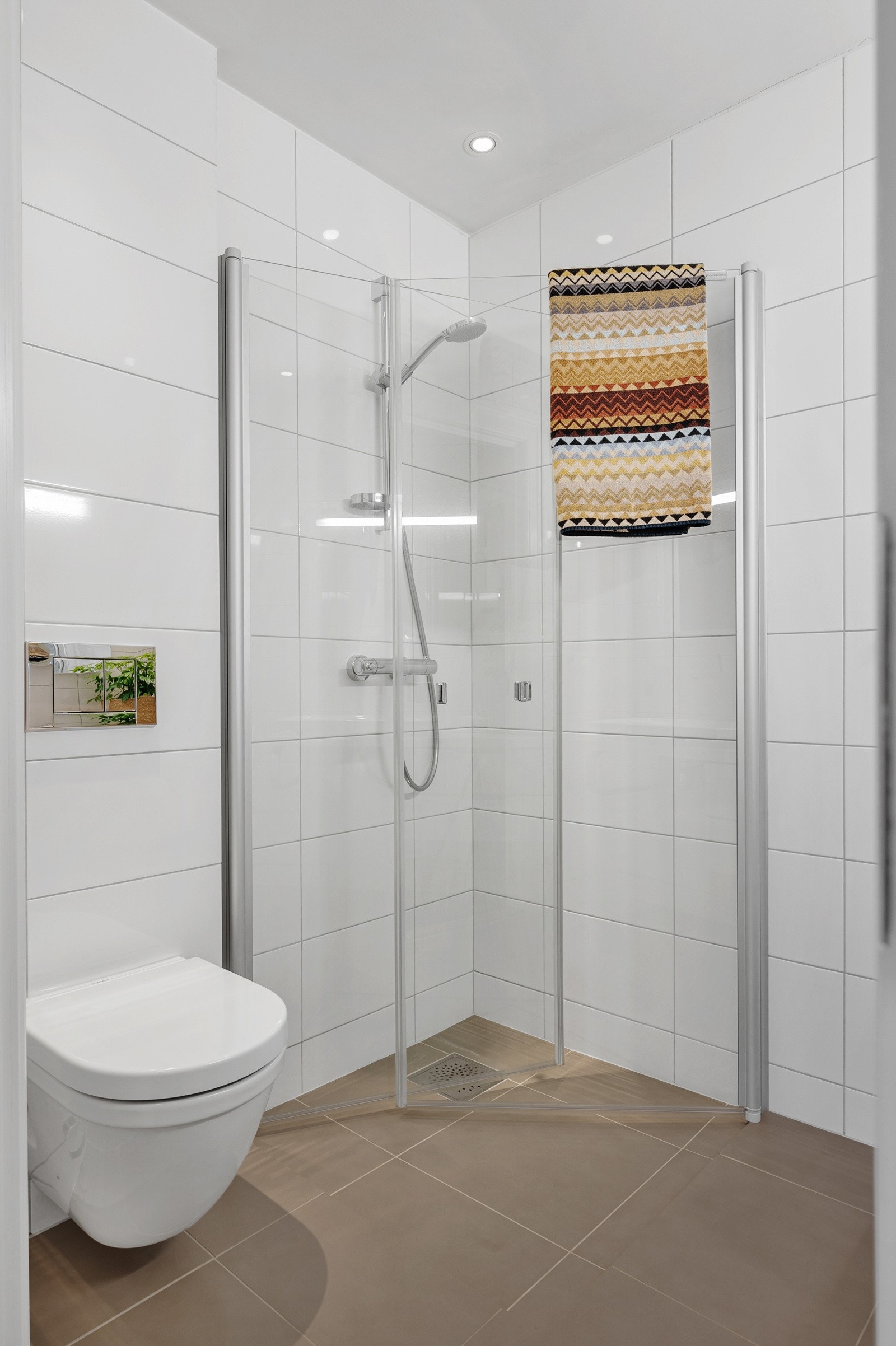 Badet er innredet med dusjhjørne, vegghengt servantinnredning og toalett. Galleribilde