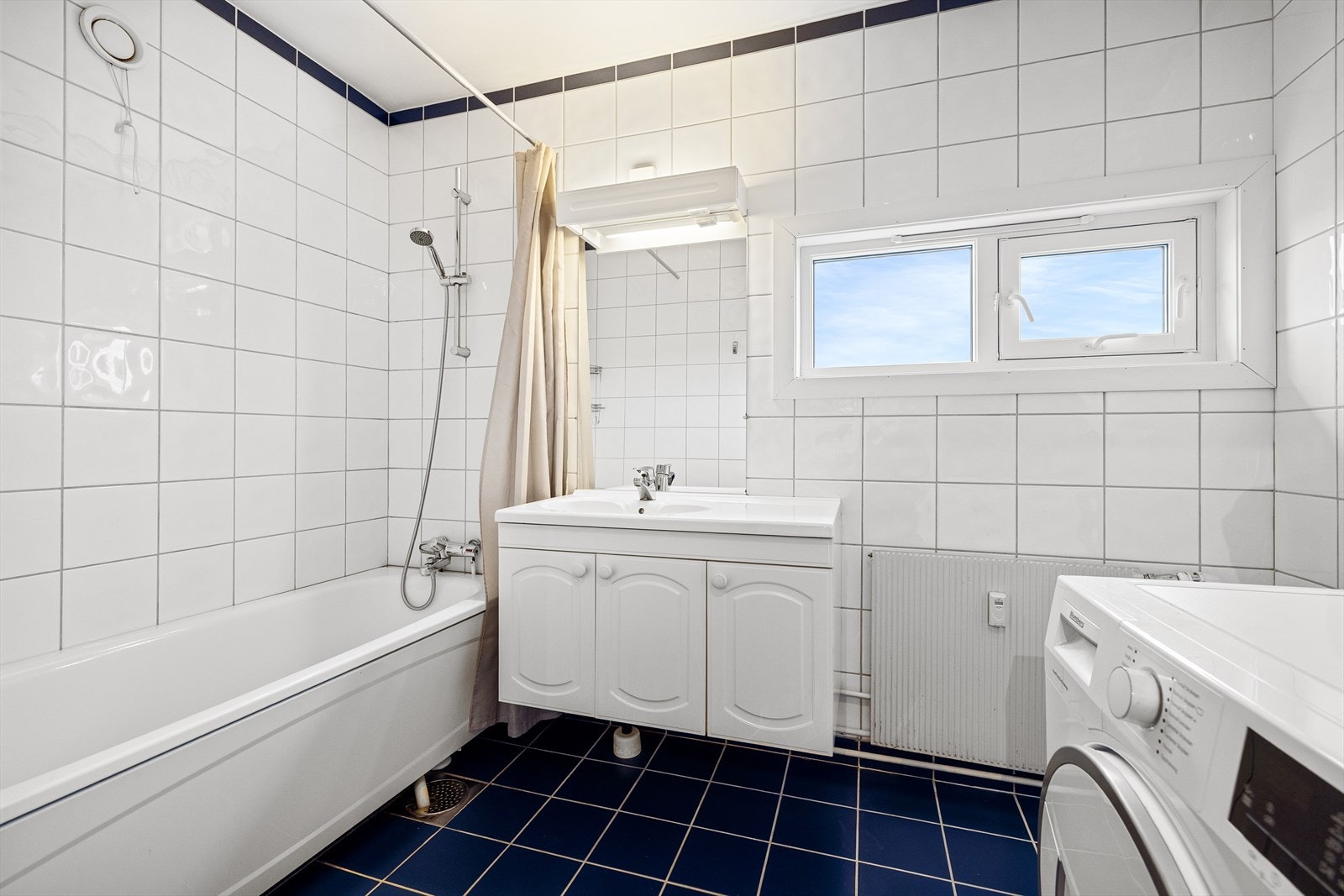 Badet er innredet med badekar og baderomsinnredning Galleribilde