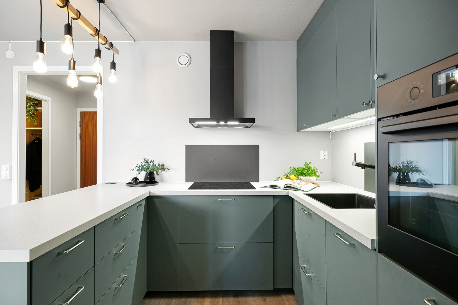 Moderne, takhøy kjøkkeninnredning med slette fronter og benkeplate i laminat. Galleribilde