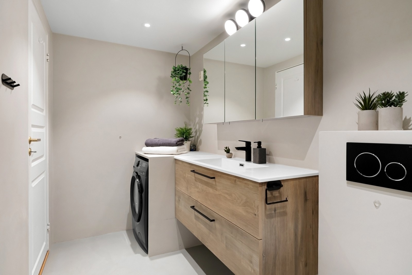 Det er bygget inn en fin løsning for vaskemaskin. Godt med oppbevaring i stort speilskap og i skuffer under servant. Galleribilde