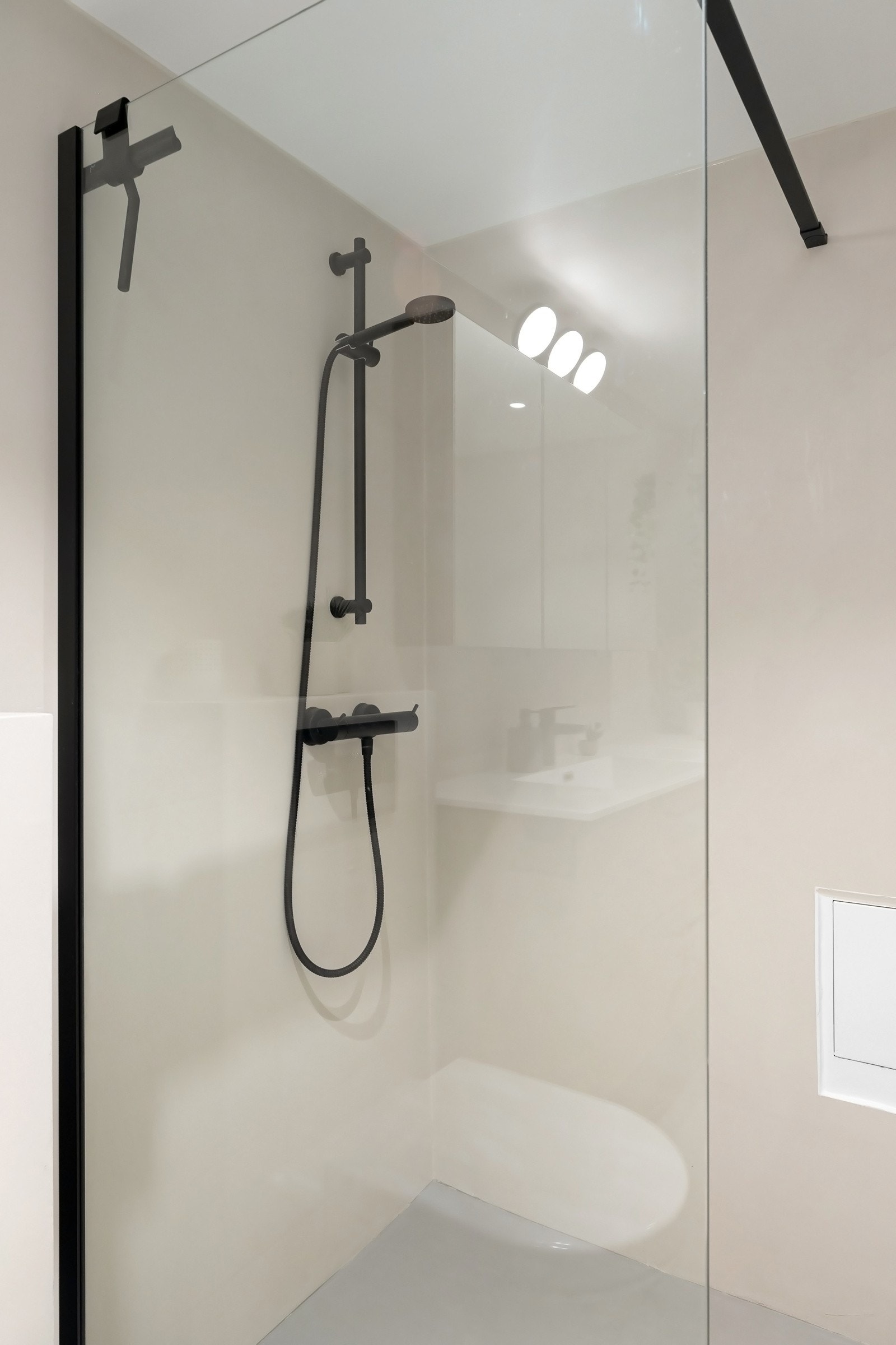 Dusjhjørne med svarte detaljer på blandebatteri og glassdør. Galleribilde