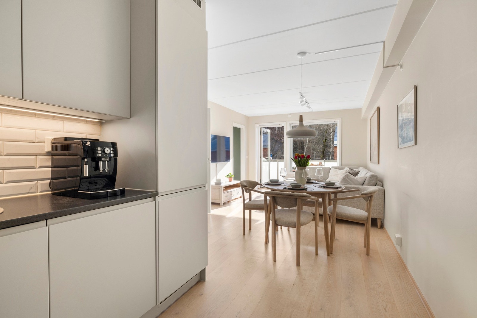 Kjøkkenet ligger praktisk plassert i et eget hjørne som holder de to delene delvis adskilt. Her kan du enkelt underholde gjestene dine samtidig som du steller i stand et bedre måltid. Galleribilde