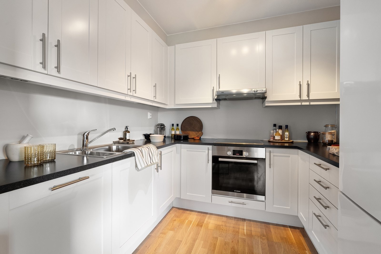 Lys og pen kjøkkeninnnredning fra Marbodal med profilerte fronter og en slitesterk benkeplate i laminat. Galleribilde