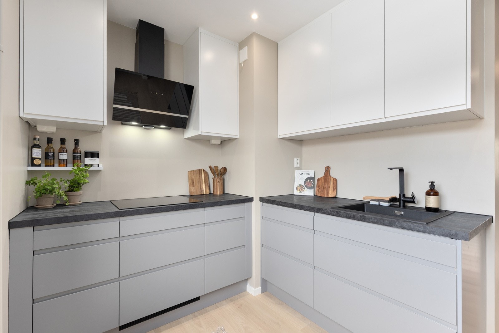 Kjøkkeninnredning med slette lakkerte fronter, laminat benkeplate og oppvaskkum. Galleribilde