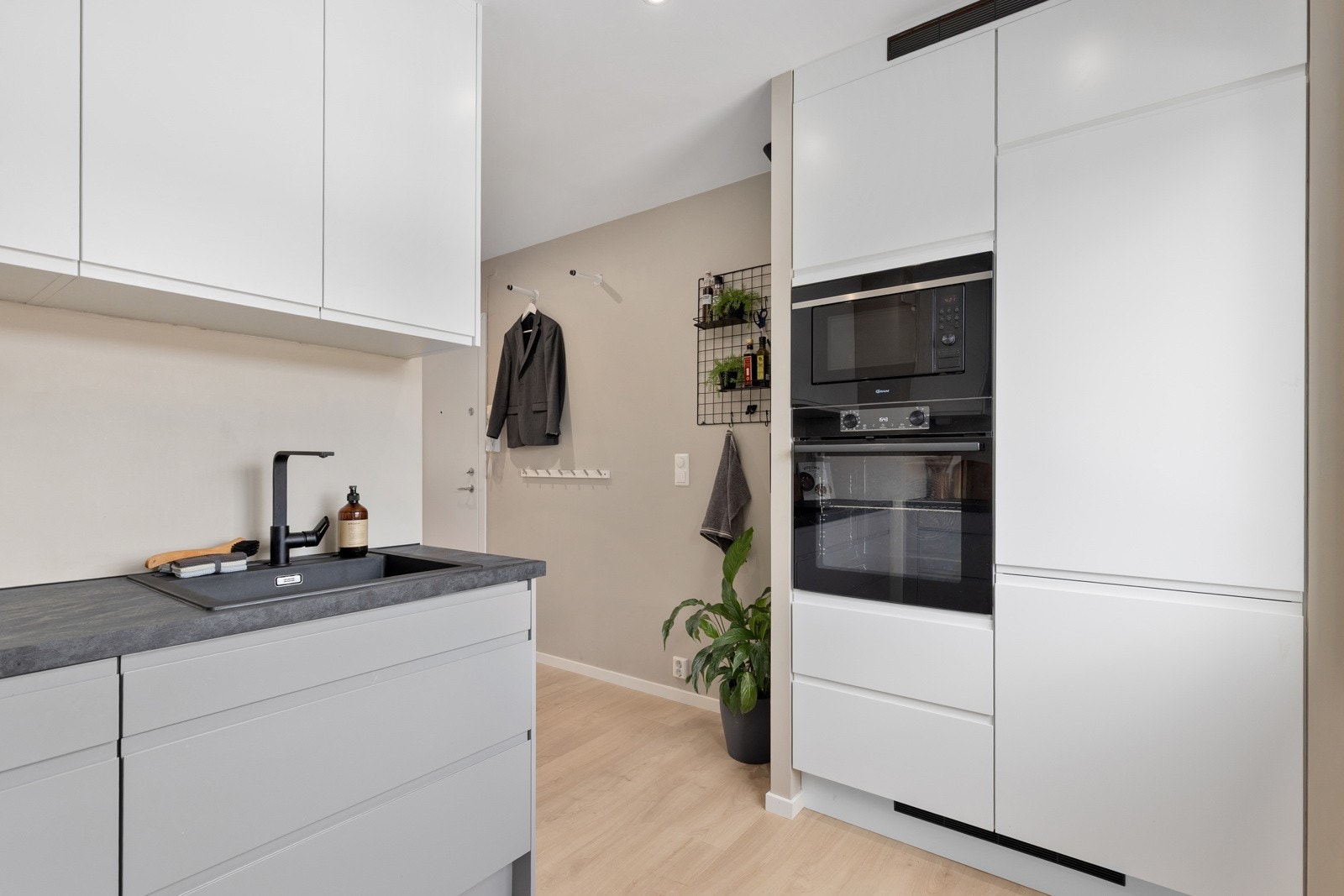 Ventilator med kullfilter og innfelte hvitevarer som stekeovn, induksjonsplatetopp, stekeovn, mikro, kjøl/frys og oppvaskmaskin. Galleribilde