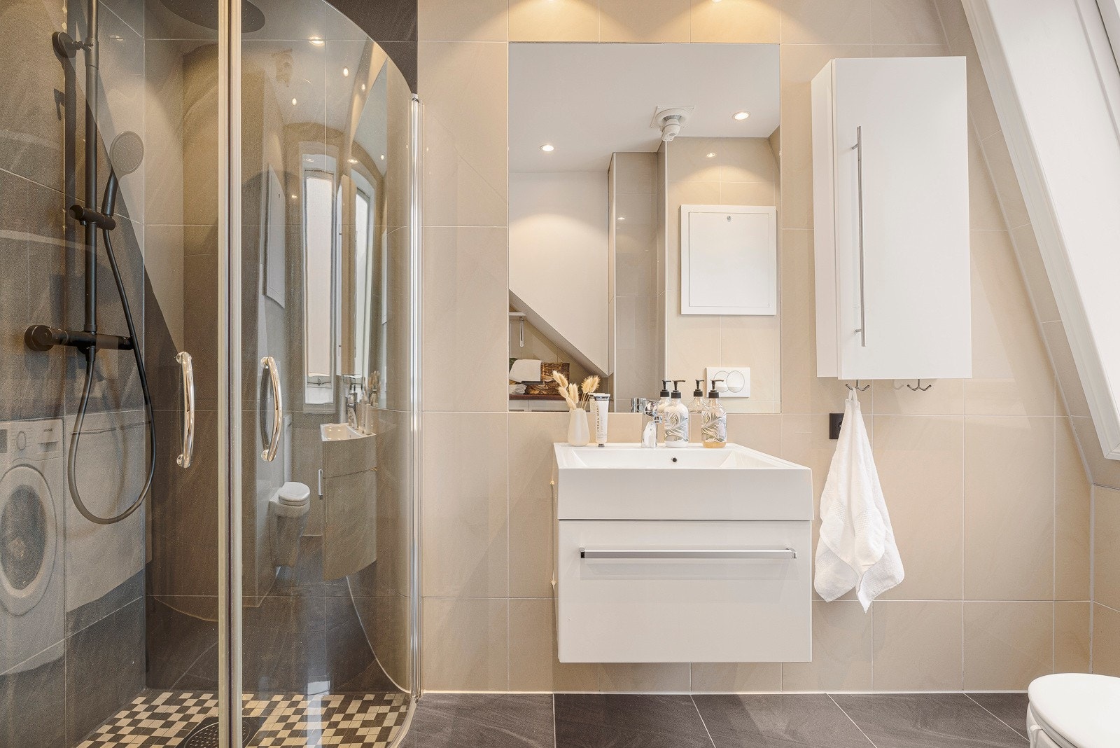 Her er det varmekabler i gulv, romslig dusjhjørne, benkeskap med servant og vegghengt toalett. Galleribilde