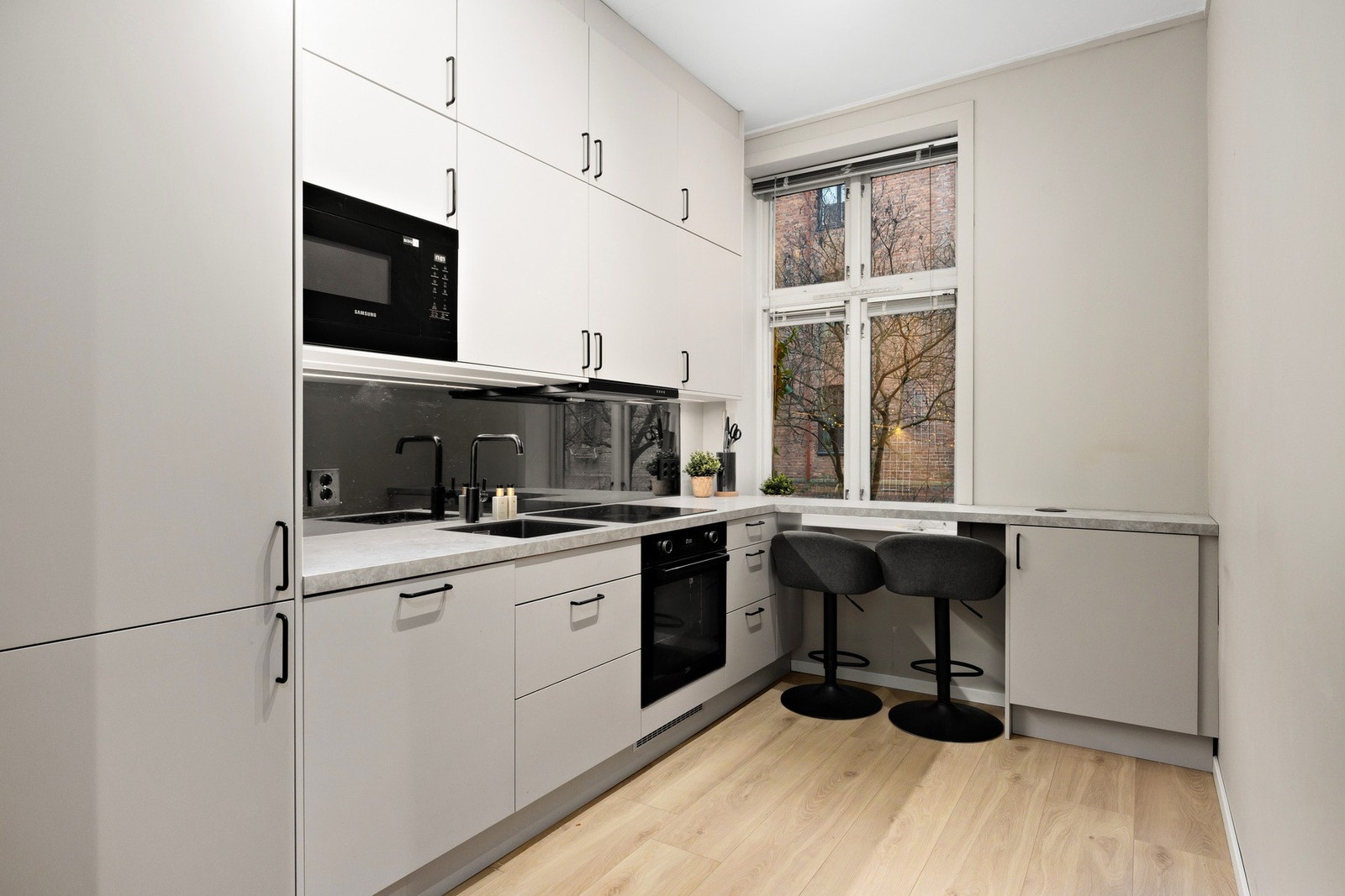 Kjøkkeninnredning med lyse glatte fronter og benkeplate i laminat. Galleribilde