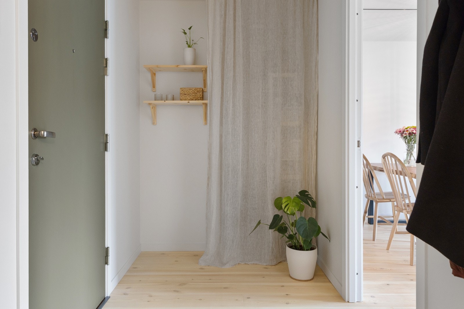 Entré med god plass til sko og oppheng av ytterklær i praktisk garderobenisje med gardin Galleribilde