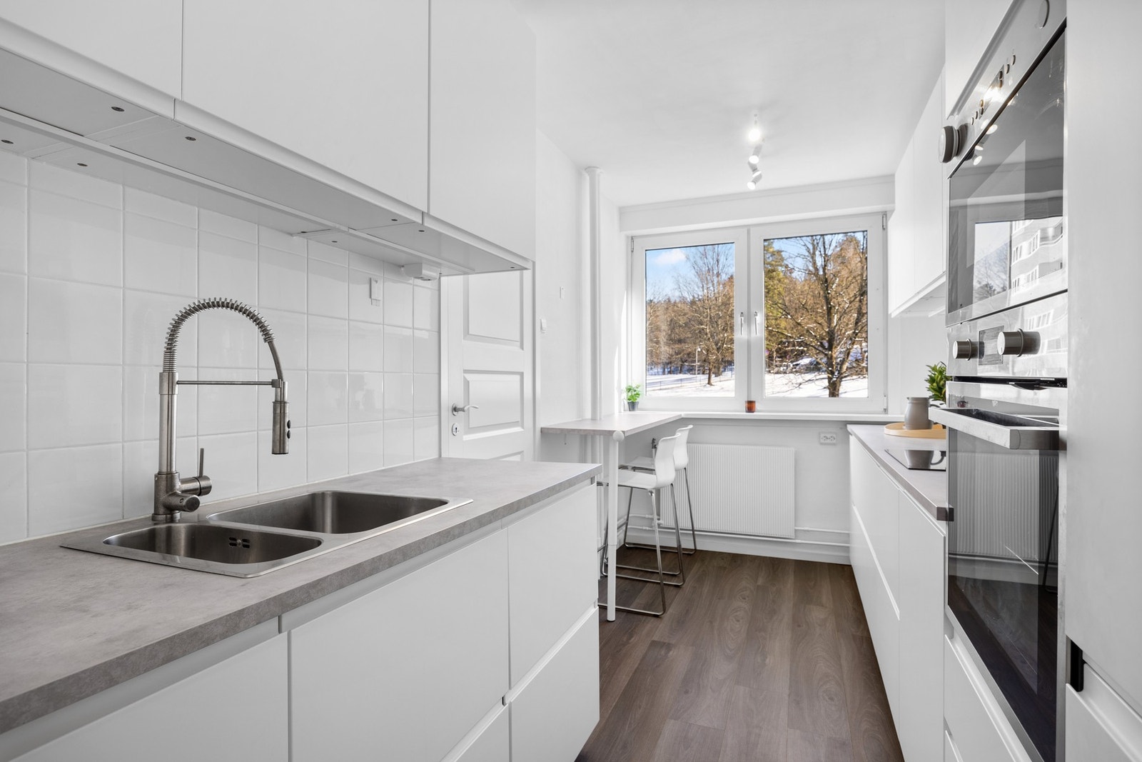 Kjøkkenet i leiligheten er fra 2019 og har en praktisk innredning fra IKEA med glatte fronter som gir et ryddig uttrykk Galleribilde