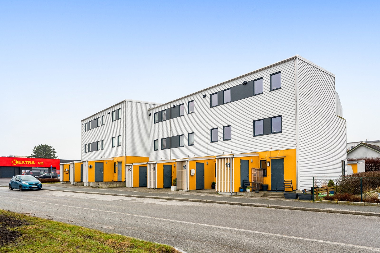 Fasaden sett fra gaten. Parkering på felles oppstillingsplass bort forbi boligen. Galleribilde