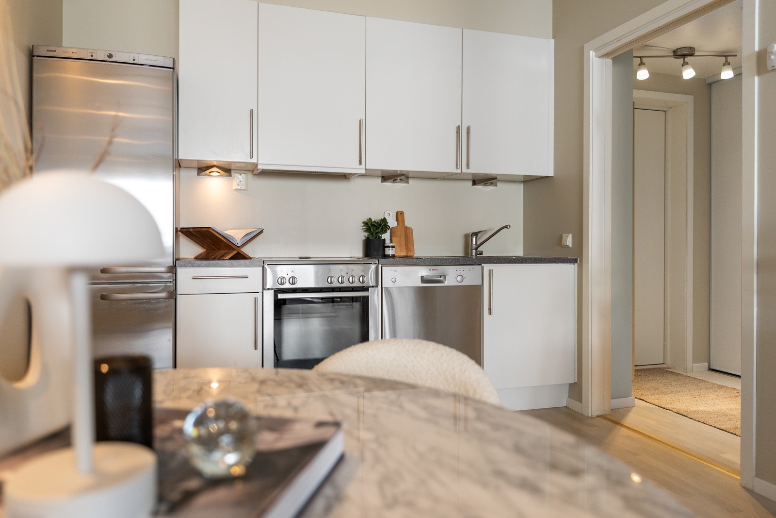 Kjøkkenet har en laminat benkeplate og slette fronter. Det er utstyrt med en stålvask med ettgreps blandebatteri samt hvitevarer, inkludert kjøl-/fryseskap, oppvaskmaskin og komfyr. Galleribilde