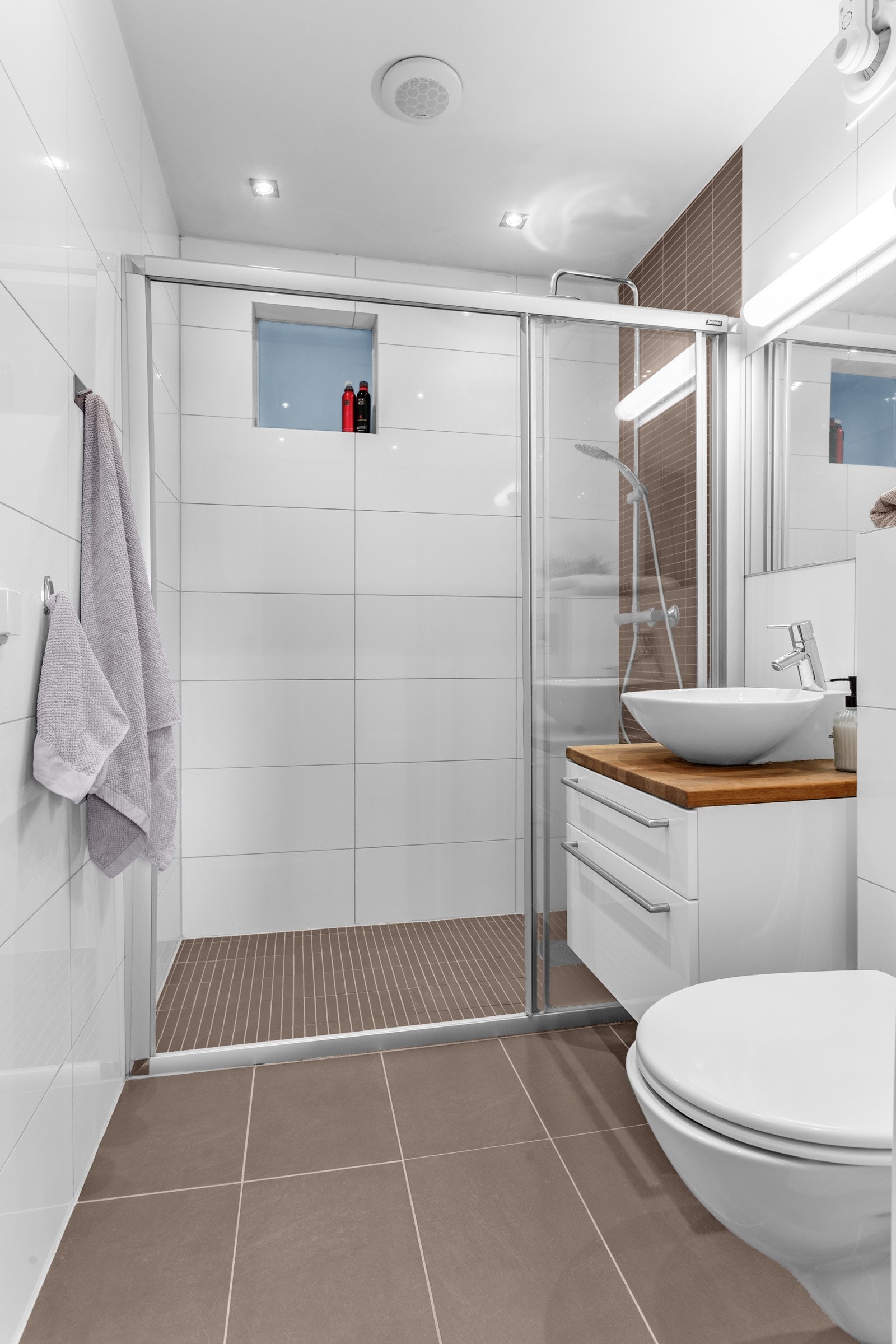 Lekkert flislagt bad med elektrisk vifte. Galleribilde