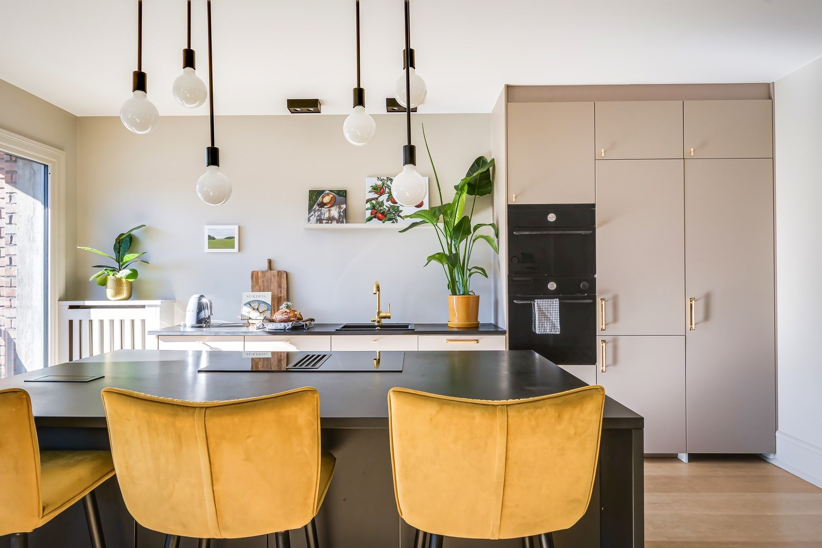 Hver detalj er nøye utvalgt - fra de lekre håndtakene i gull til den mørke benkeplaten som skaper en sofistikert kontrast. Galleribilde