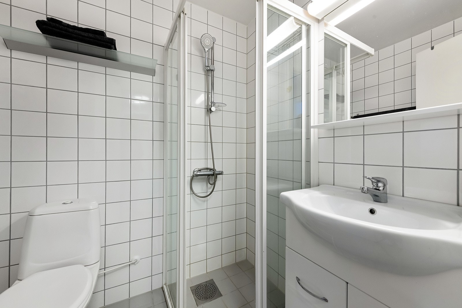 Badet er flislagt på gulv og vegger. Stilren innredning. Galleribilde