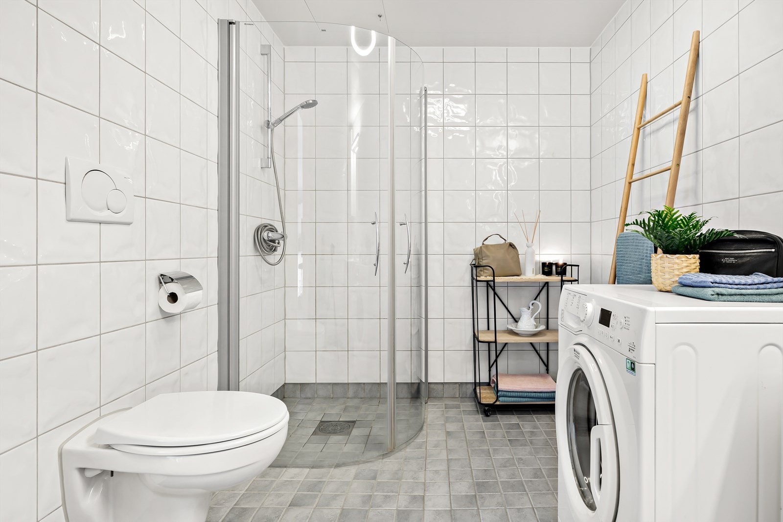 Baderomsinnredningen består av servant med over- og underskap, dusjhjørne og vegghengt toalett. Det er opplegg til vaskemaskin. Galleribilde