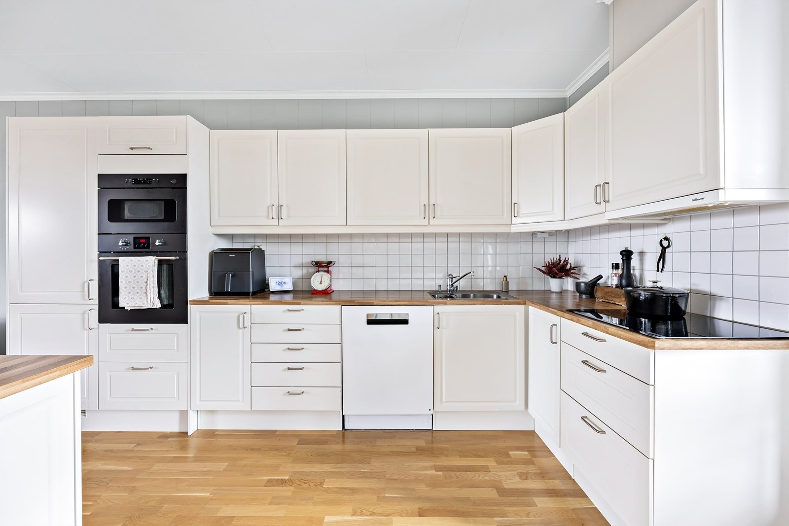 Kjøkkeninnredningen består av skap med lyse profilerte fronter og benkeplate i laminat. Galleribilde