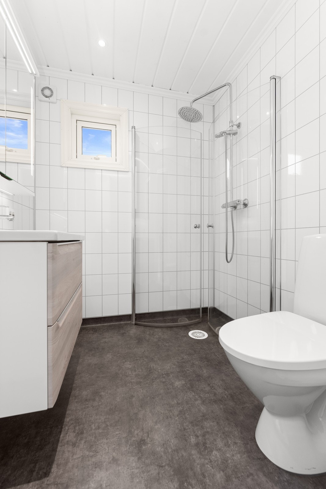 Badet har nyere overflater. Her er våtromsplater på vegger og panel i himling med spotter samt belegg på gulv med varmekabler. Galleribilde