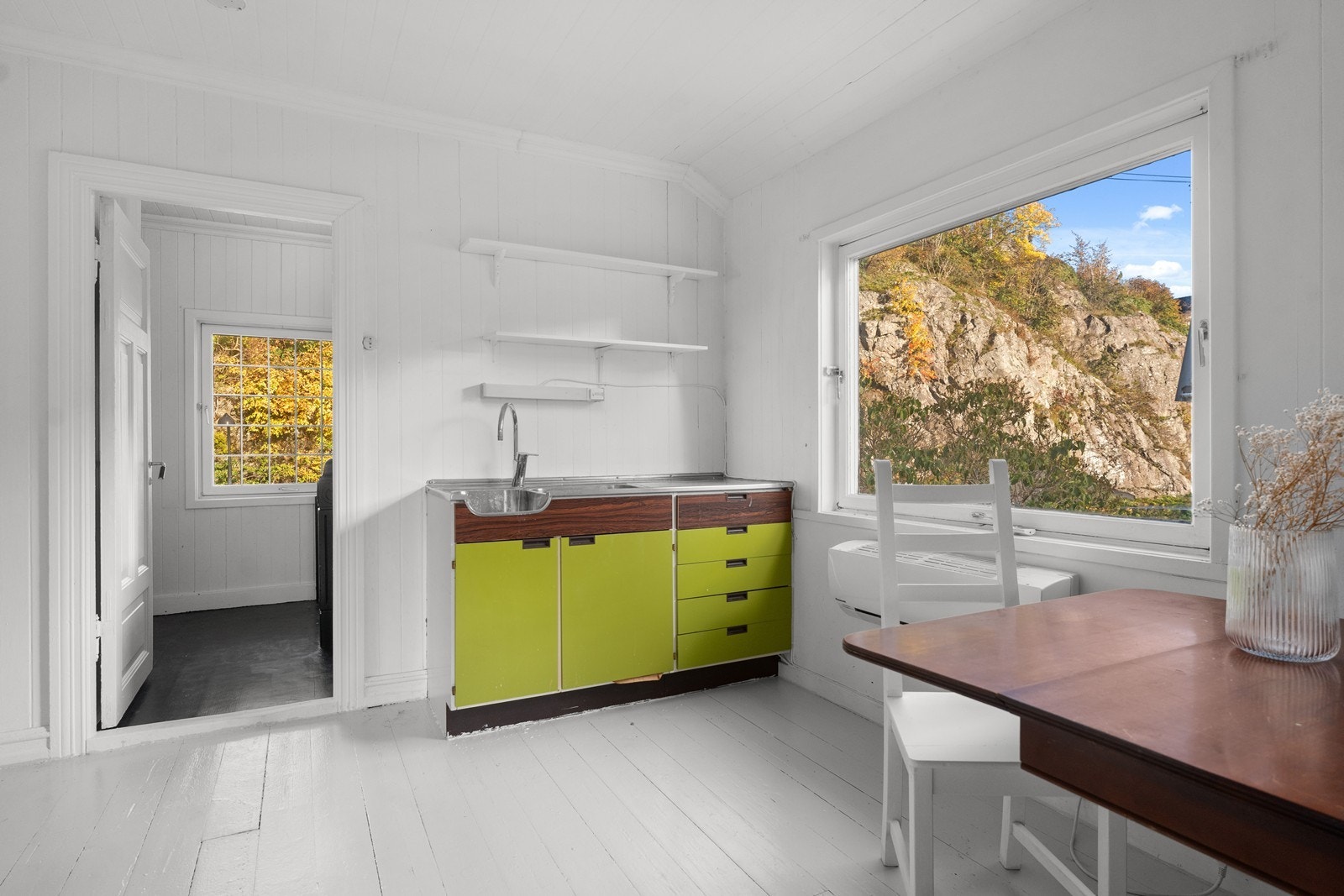 Rom med eldre lite kjøkken og varmepumpe Galleribilde