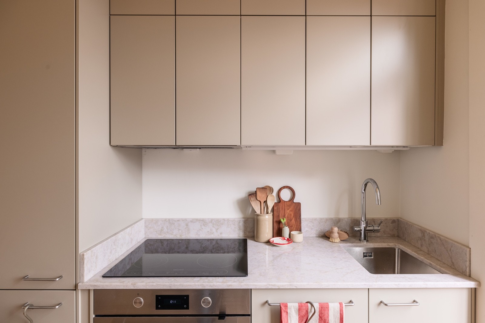 God oppbevaringsplass i takhøye overskap med belysning under. Det er også montert ny komfyrvakt ved platetoppen i 2025 og lekkasjestopper i benkeskap. Galleribilde