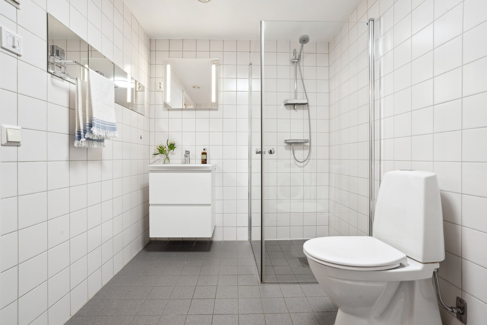 Badet er innredet med en servant med underskap og speil med belysning. Galleribilde