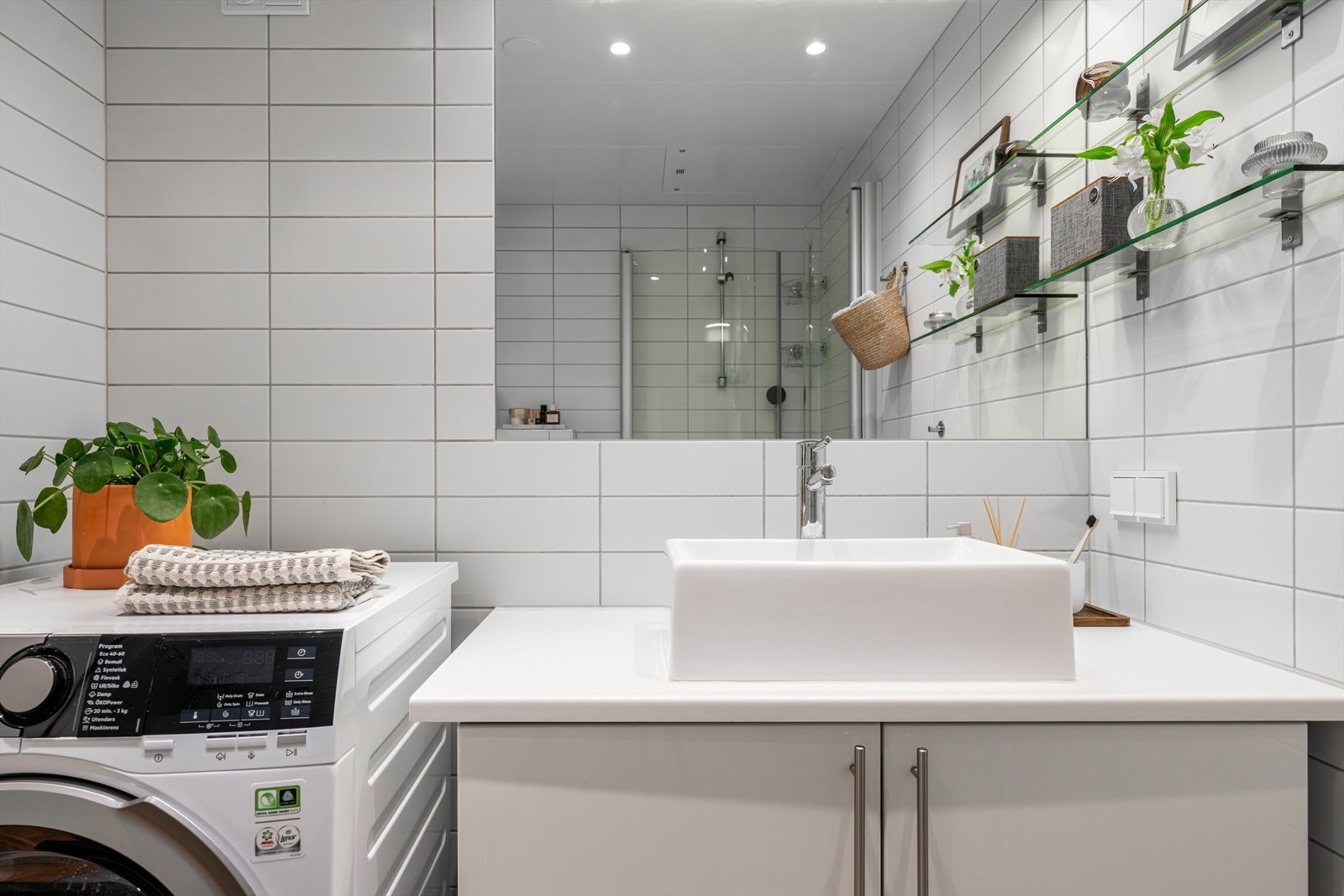 Servant med ett greps blandebatteri og vegghengt toalett. Galleribilde